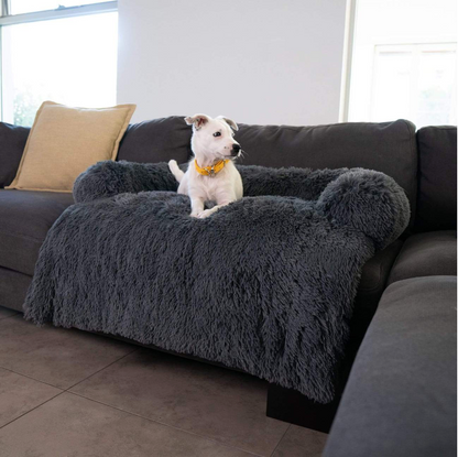 Small dog sitting on Inspaws fluffy faux long fur couch cover sofa bed in dark grey