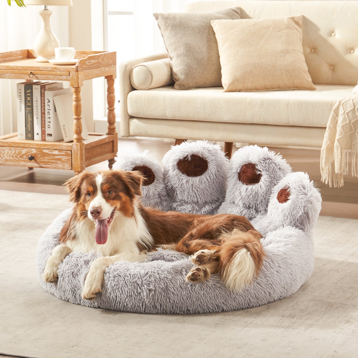 Border collie dog lounging in Inspaws light grey plush faux fur calming paw dog bed on living room floor