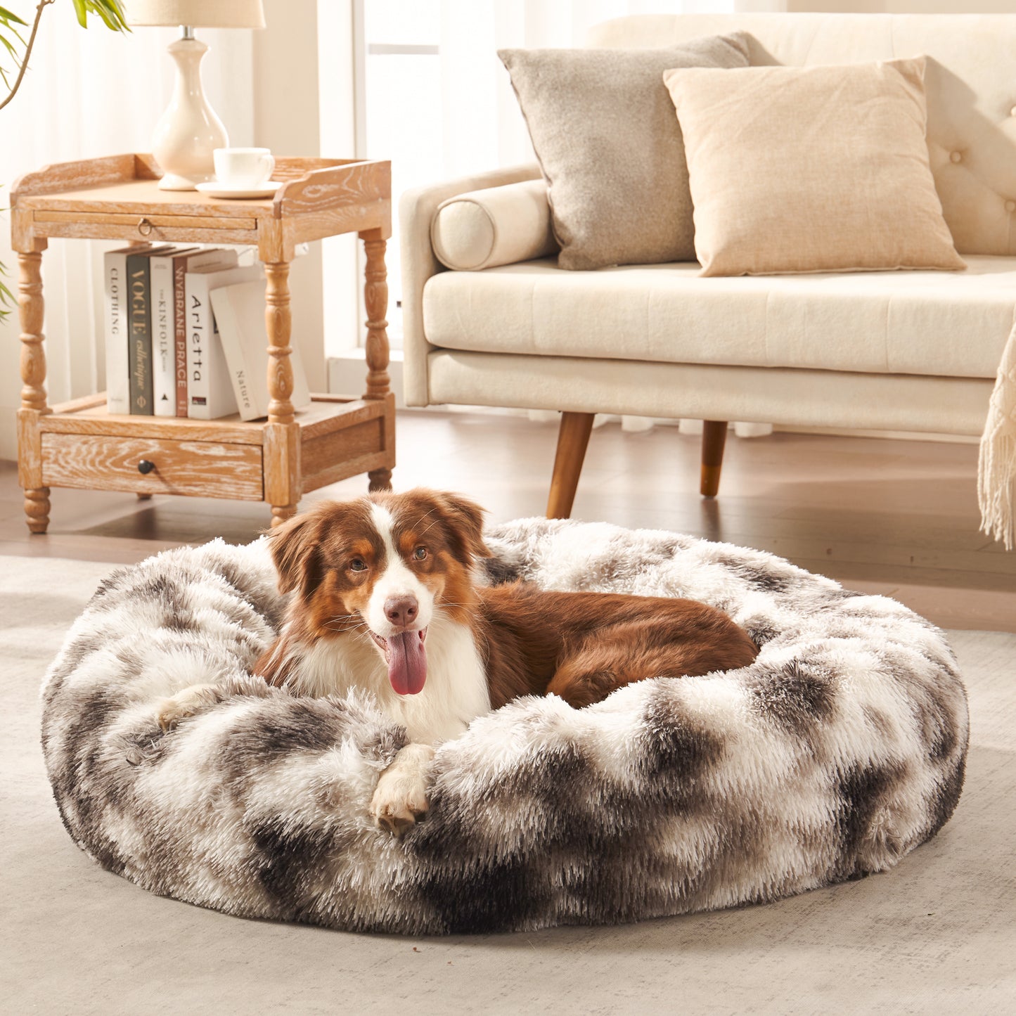 Dog resting in Inspaws calming donut dog bed in ink tie-dye plush faux fur