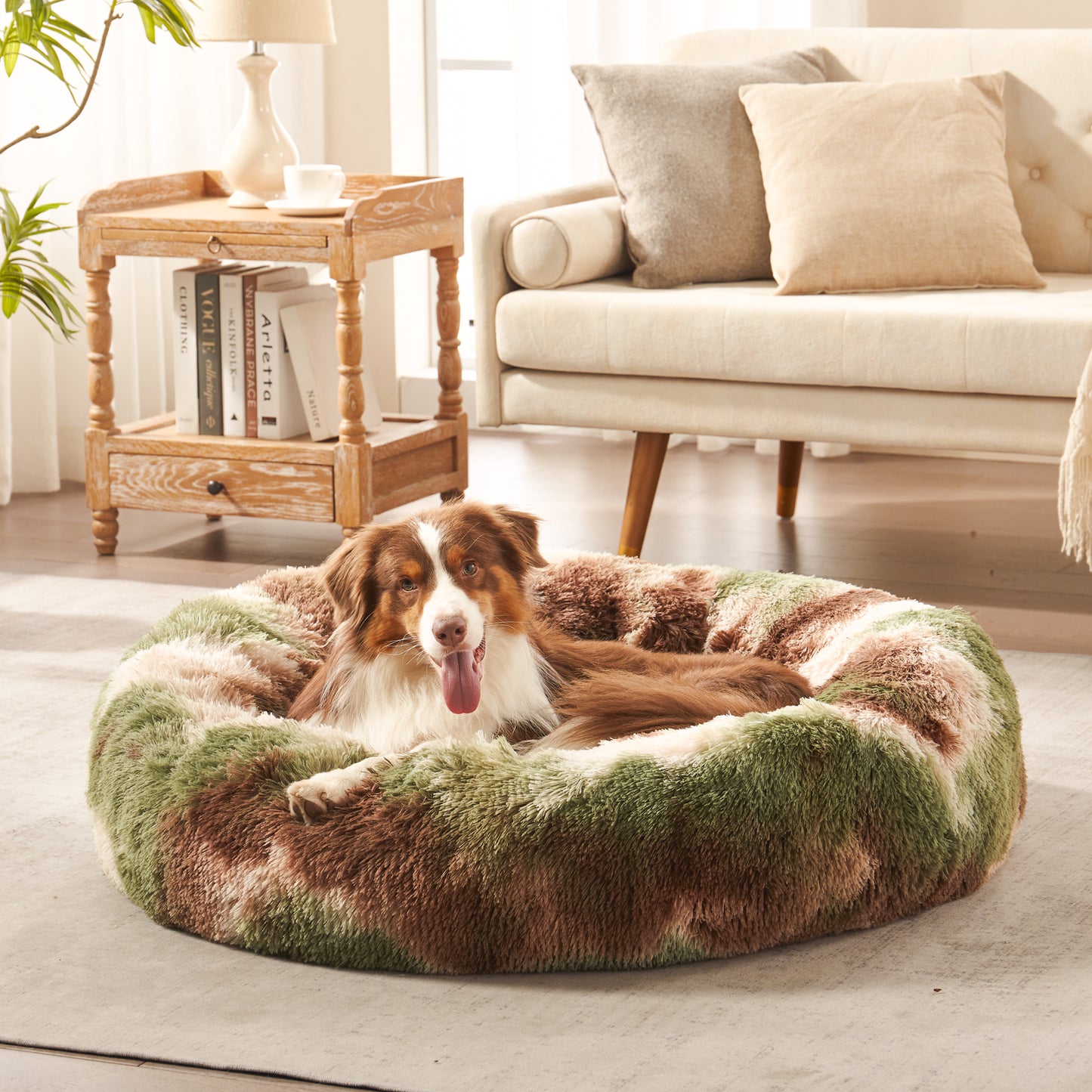 Dog resting in Inspaws calming donut dog bed in green camo plush faux fur