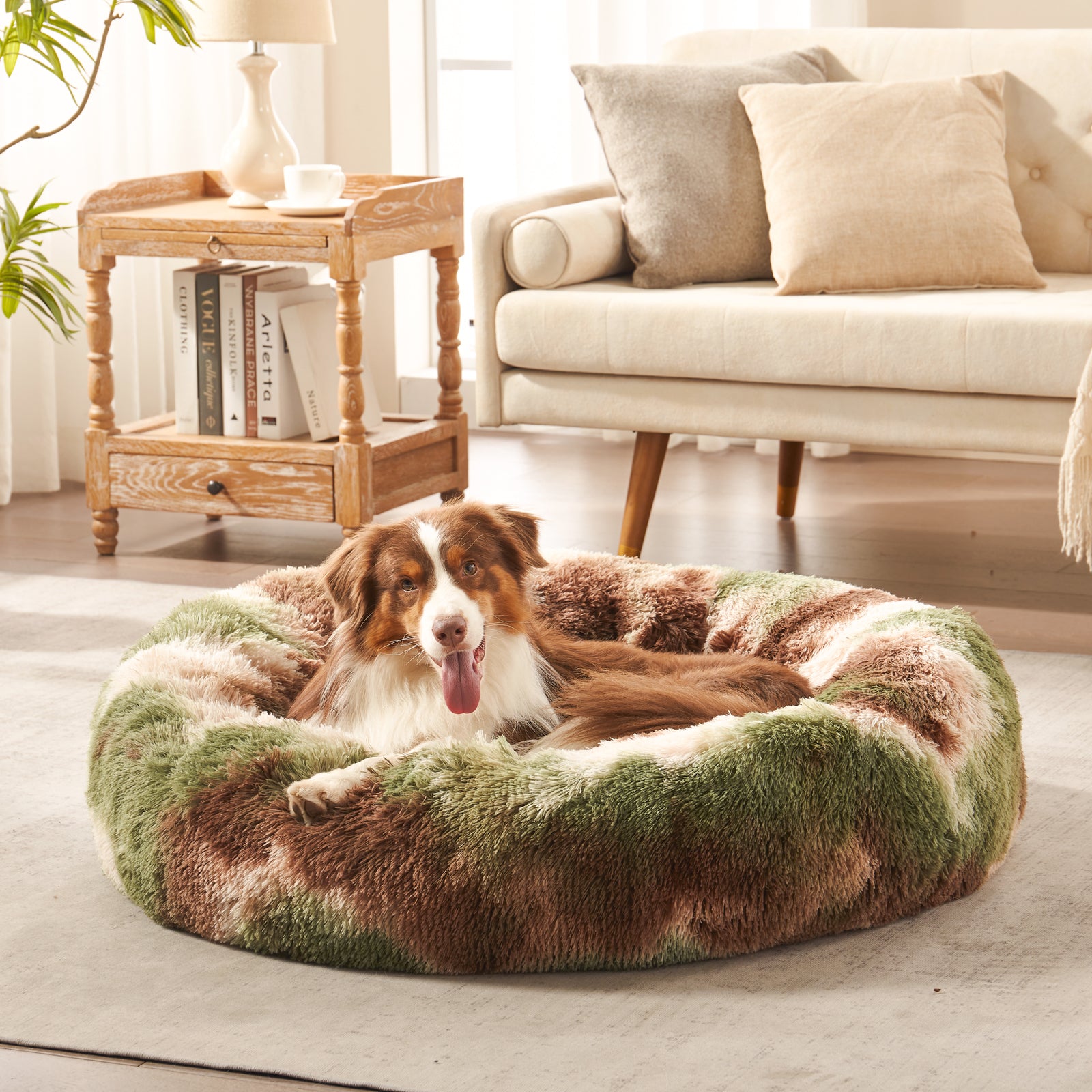 Dog resting in Inspaws calming donut dog bed in green camo plush faux fur