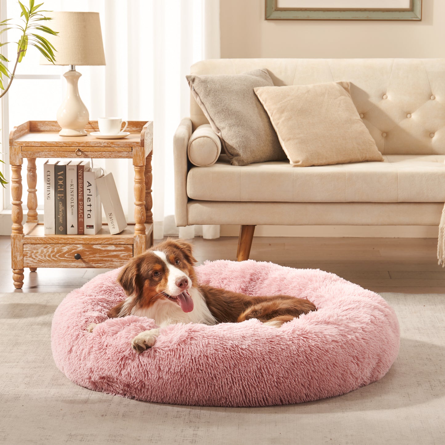 Dog resting in Inspaws calming donut dog bed in blush pink plush faux fur