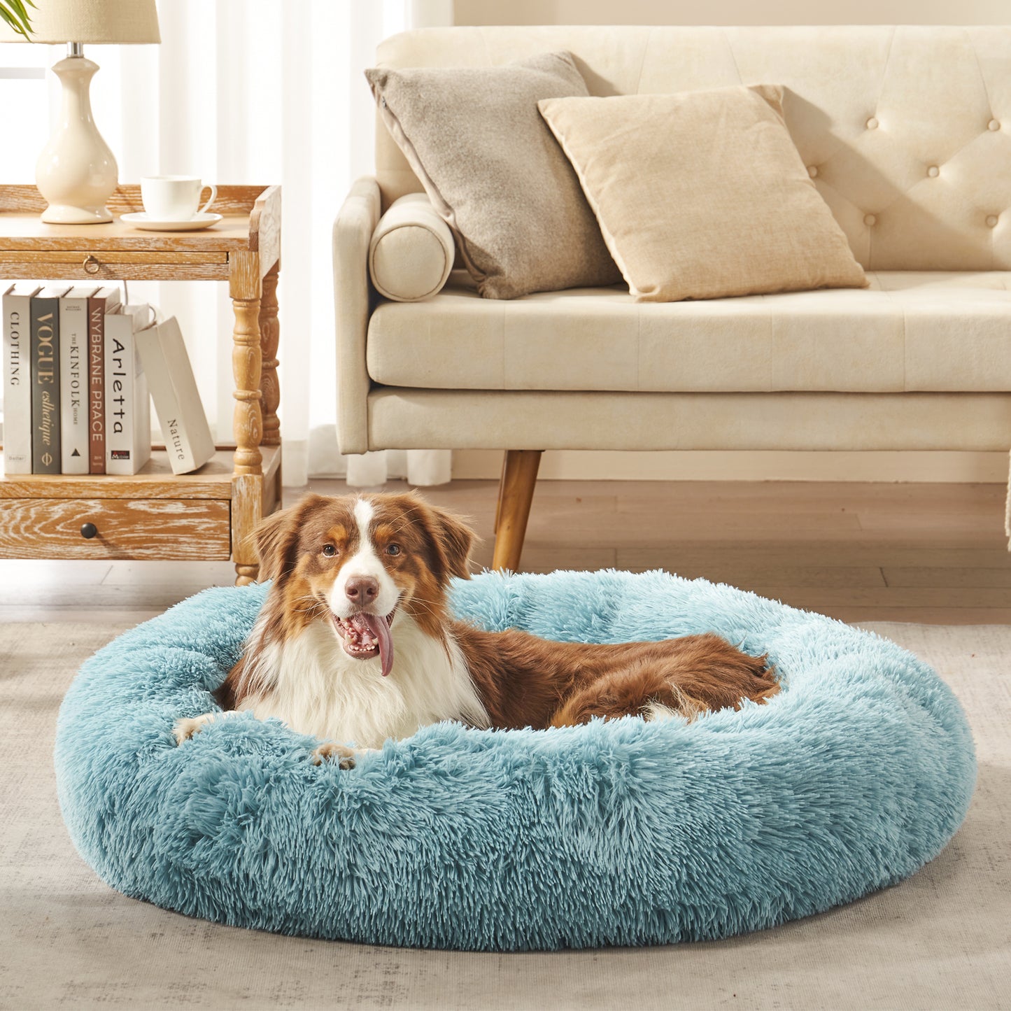 Dog resting in Inspaws calming donut dog bed in mint green plush faux fur